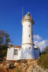 White old lighthouse against the blue sky.
