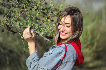 Young girl near the conifer tree's branch