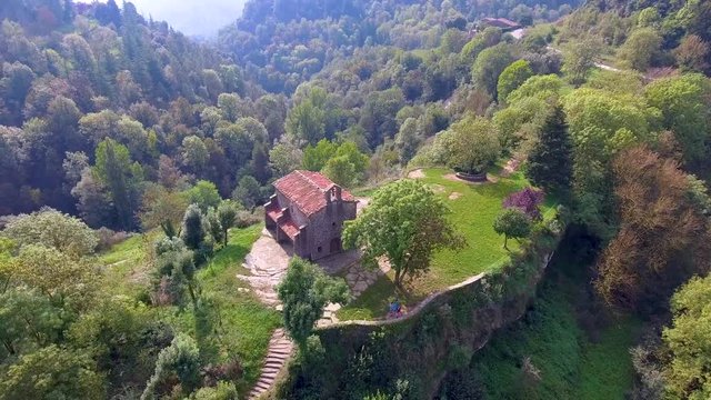 Aerial view around Hermitage of Santa Magdalena located in a hilltop of a mountain in front of Rupit It is a romanesque church dated from 16th century. Barcelona province, Catalonia, Spain.