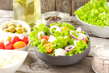 Healthy salad in bowl on wooden background. Top view