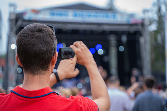Mężczyzna fotografuje koncert telefonem