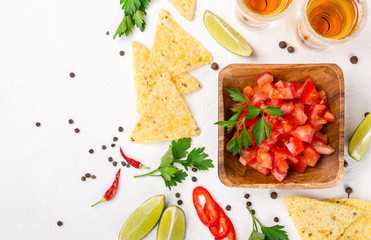 Mexican food salsa, chips and tequila shots with lime