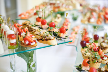 Catering. Off-site food. Buffet table with various canapes, sandwiches, hamburgers and snacks.