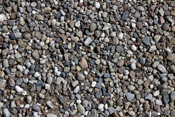 Small pebbles of different colors and sizes on the banks of the river.