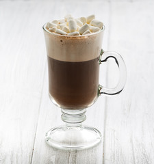 Hot chocolate with marshmallow and cinnamon in a glass with double walls