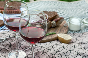 Meat kebab is visible through a glass of red wine. Soft focus.