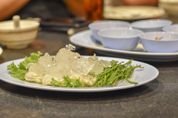 Fresh oysters on ice at seafood restaurants.Ready for eat or serving, Green acacia vegetables placed beside.