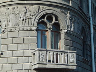 Balcony and beautiful arch-shaped window in the wall of a vintage house