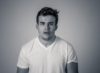 Obraz premium Natural portrait of young attractive man in his 20s looking and posing with neutral face expression