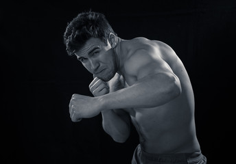 Fototapeta na wymiar Strong muscly man throwing a fierce and powerful punch