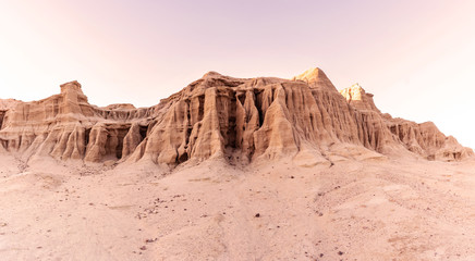 Sandstone rocks and dunes in a desert at sunset time. California, USA.