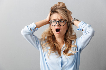 Photo of upset puzzled businesswoman wearing eyeglasses screaming and grabbing her head