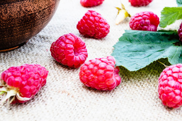 Ripe red raspberry lies on the background of old boards. Selective focus.