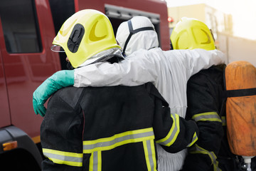 firefighter help and carry victim people from disaster out danger area