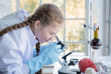 girl in high school students using microscopes in laboratory