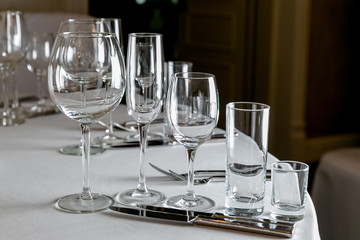 Beautiful table setting with crockery for a party, wedding reception or other festive event. Empty glassware and cutlery for catered event dinner. Horizontal photo