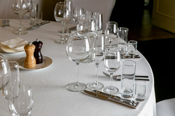 Beautiful table setting with crockery for a party, wedding reception or other festive event. Empty glassware and cutlery for catered event dinner. Horizontal photo