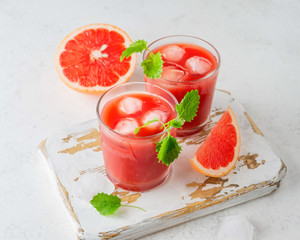 Ripe cut grapefruits and glass of freshly squeezed grapefruit juice