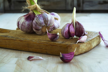 Purple garlic on a wooden board. Close-up. Rustic style.