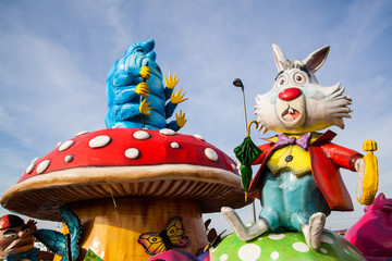 A caterpillar Absolem and white rabbit sitting on mushroom giant sculpture from Alice in wonderland on a carnival parade