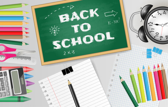 Back to school text on chalkboard with school supplies on gray background