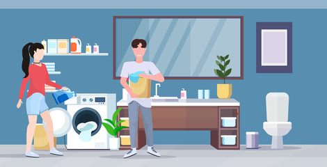 man woman with basket of clothes couple loading laundry to washing machine doing housework housekeeping concept modern bathroom interior cartoon character full length flat horizontal