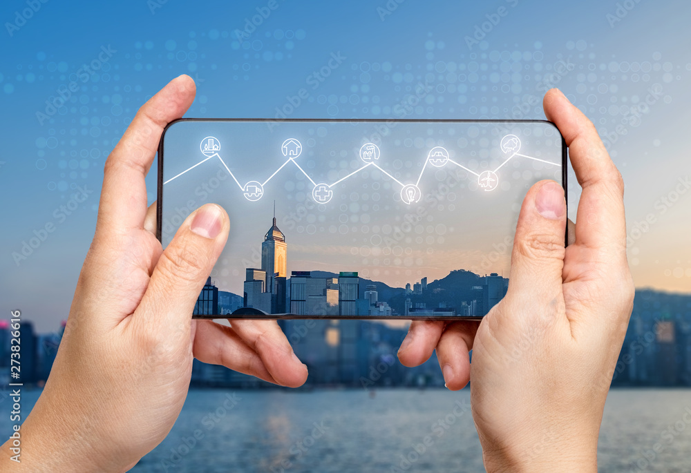 Poster hand holding mobile with internet of things (iot) word on screen with icon feature glowing in air wi