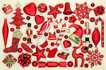 Large collection of red Christmas tree decorations on cream background.