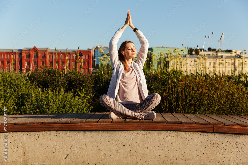 Sticker Beautiful young sports woman sitting outdoors