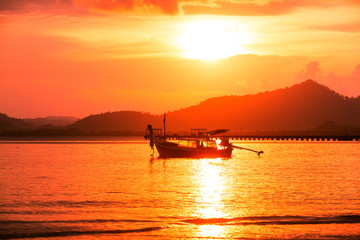 Fototapeta na wymiar Silhouette of beautiful sunset with fishing boat