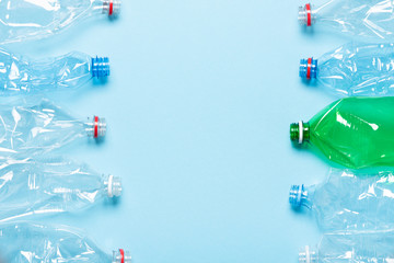 Single use plastic bottles on blue background with copy space top view