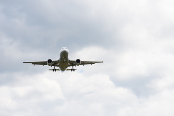 Airplane in white clouds prepare for landing.