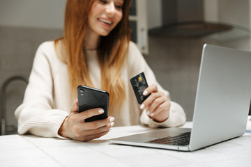Attractive young girl sitting at the kitchen at home