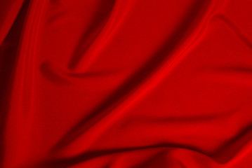 Red silk or satin luxury fabric texture can use as abstract background. Top view.