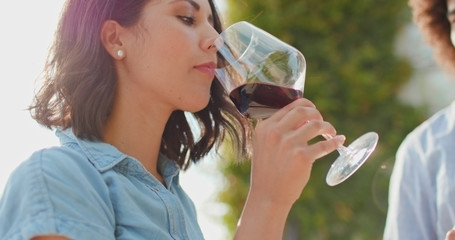 Romantic couple, woman drinking red wine and smiling at sunset warm light. Friends italian trip in...