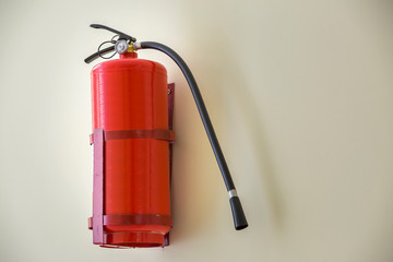 Fire extinguisher bright red isolated on white wall copy space background. Danger and safety, fire...