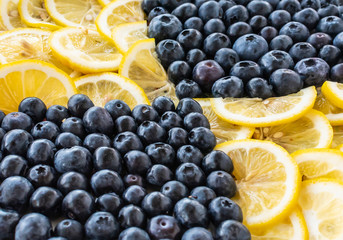 Blueberry berries and lemon slices. Blue and yellow checkered pattern background.