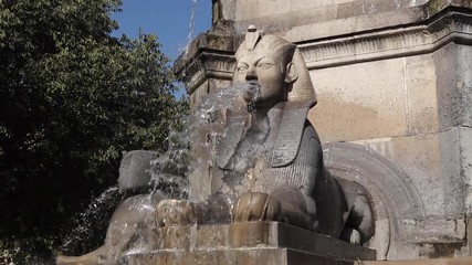 Beautiful Pharaoh sculpture spitting water in a fountain in Chatelet, Paris. Sunny summer afternoon with blue sky. Street Parisian beauty. Sphinx Statue, Palmier Fountain, fountain of the Chatelet.