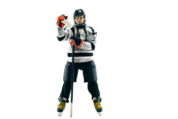 Young female hockey player isolated on white background. Sportswoman wearing equipment and helmet...