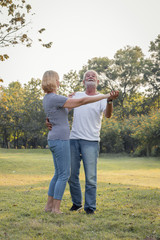 Senior couples dance together in the park.