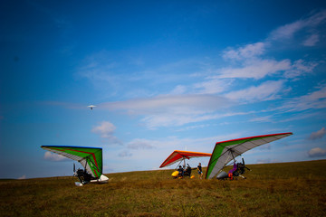 Motorized gliders stand on the ground against the background of a golobugo sky