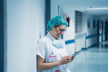 Beautiful female doctor using mobile phone at hospital