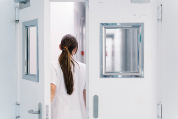 Back view unrecognizable of doctor coming out of pediatric department of hospital after work