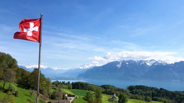 Swiss flag blowing in the breeze on a farm atop Mont Pelerin, Switzerland.