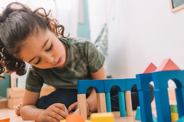 girl playing in her room with building blocks