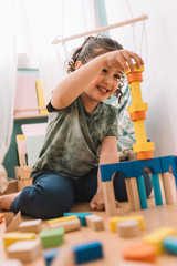 happy little girl playing with building blocks