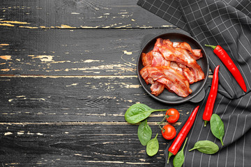 Frying pan with cooked bacon on dark table - obrazy, fototapety, plakaty