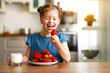 happy child girl eating strawberries with milk  .