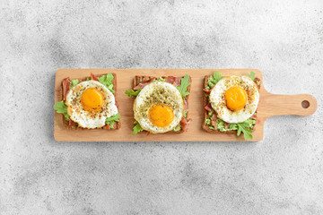 Board with tasty toasts on grey background