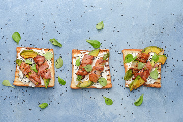 Tasty toasts with bacon on color background